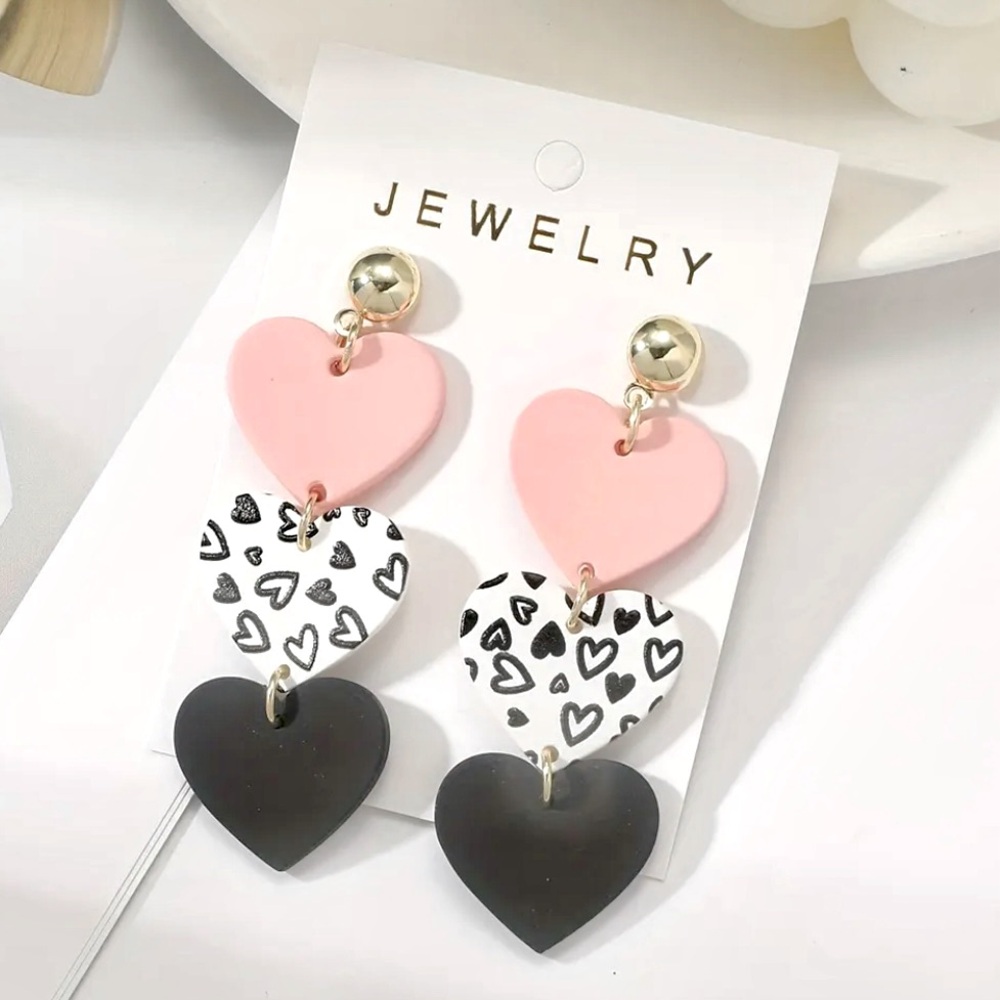 A TRIO of dangling, acrylic heart Earrings